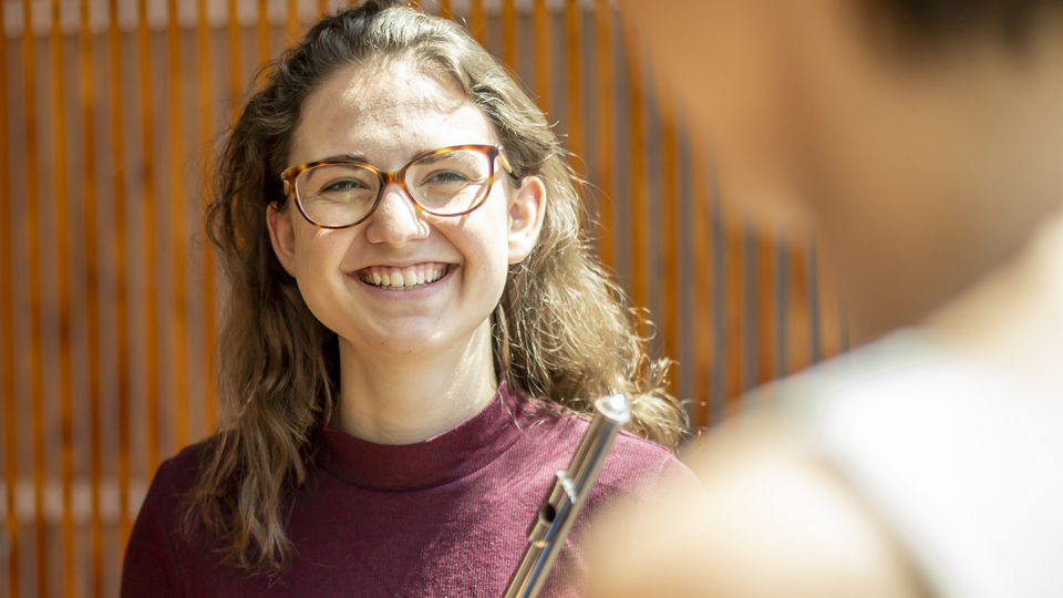 Flute player laughing and talking to colleague
